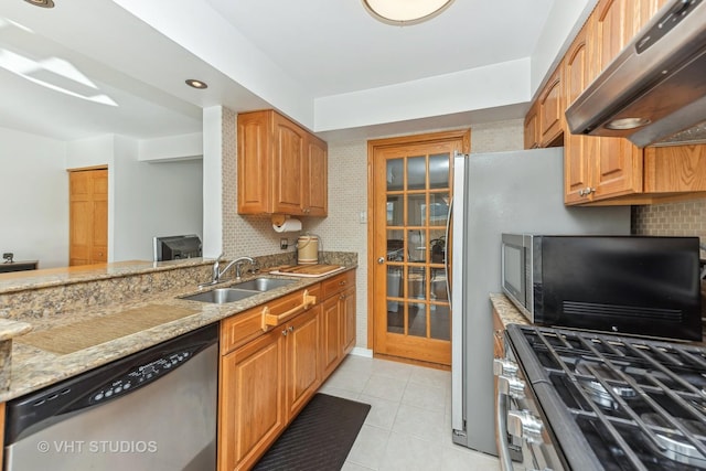 kitchen with tasteful backsplash, light stone counters, stainless steel appliances, extractor fan, and sink