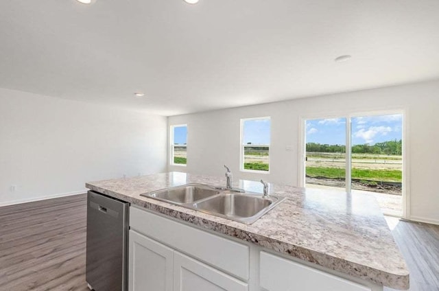 kitchen with dishwasher, sink, hardwood / wood-style floors, a center island with sink, and white cabinets