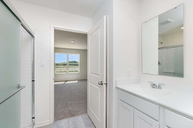 bathroom featuring a shower with door and vanity