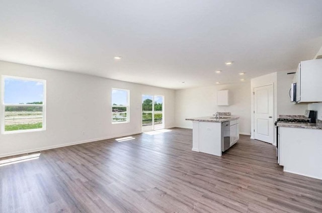 kitchen featuring white cabinets, a center island with sink, sink, appliances with stainless steel finishes, and dark hardwood / wood-style flooring