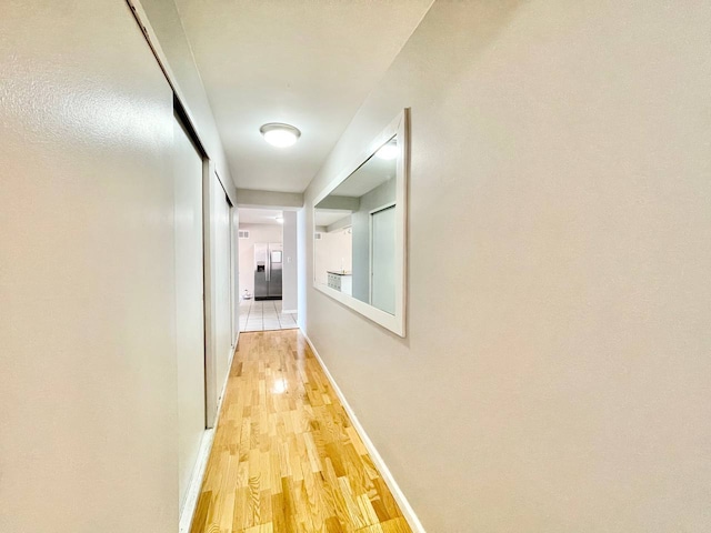 hallway with hardwood / wood-style flooring