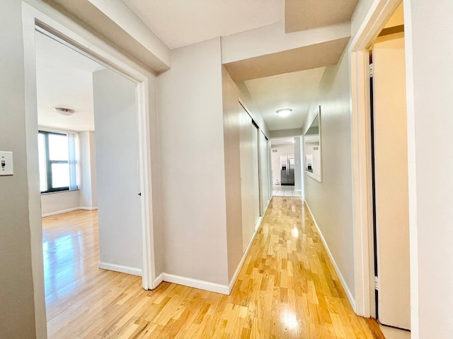 corridor with light hardwood / wood-style floors