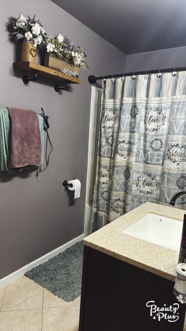 bathroom with a shower with curtain, vanity, and tile patterned floors