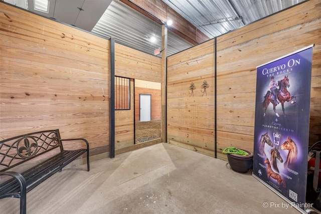 living area featuring wood walls and concrete floors