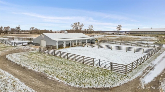 back of property with a rural view and an outbuilding