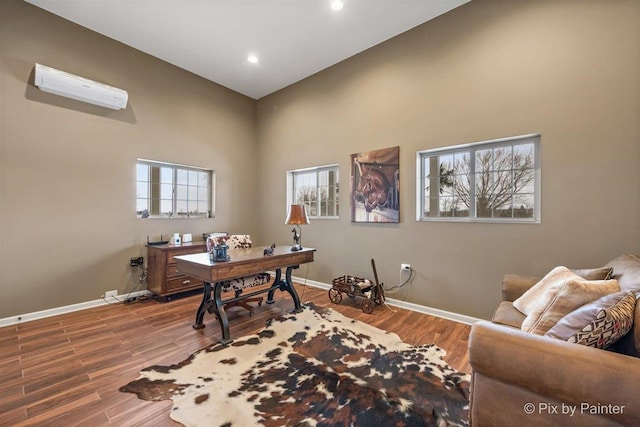 office area featuring wood-type flooring and a wall mounted air conditioner