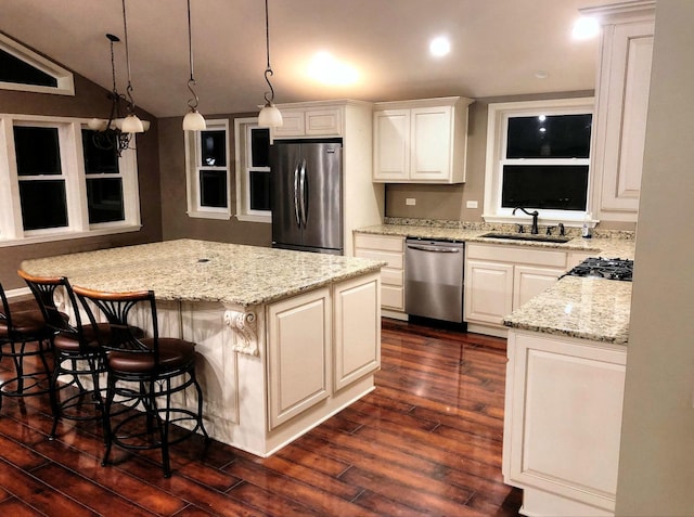 kitchen with white cabinets, hanging light fixtures, sink, and appliances with stainless steel finishes