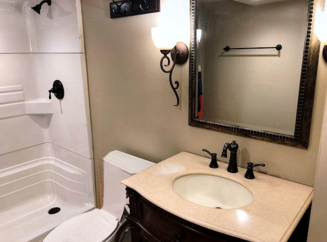 bathroom featuring vanity, toilet, and walk in shower