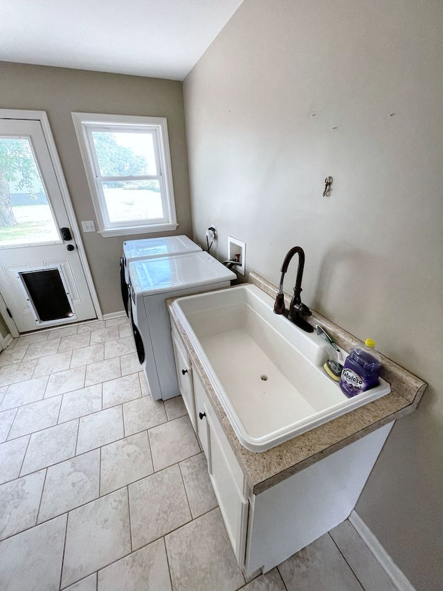 laundry room featuring cabinets, sink, light tile patterned floors, and washer and dryer