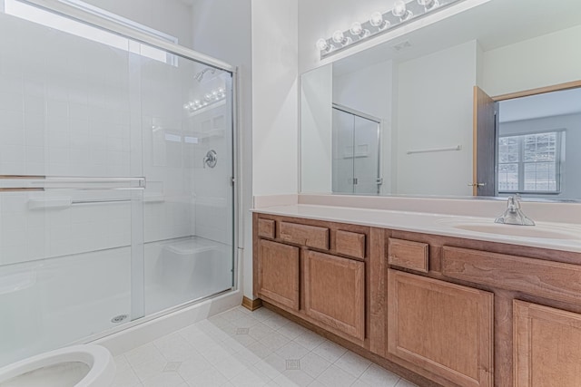 bathroom featuring a wealth of natural light, a shower with door, and vanity