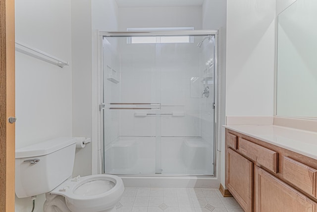 bathroom featuring vanity, toilet, and a shower with door