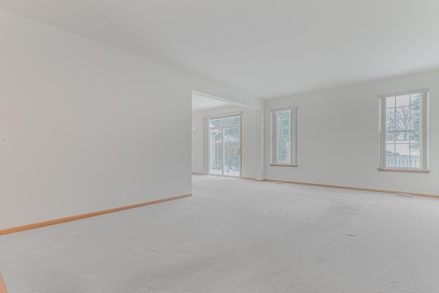 carpeted spare room featuring plenty of natural light