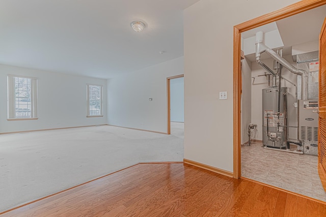 spare room featuring gas water heater and light hardwood / wood-style flooring