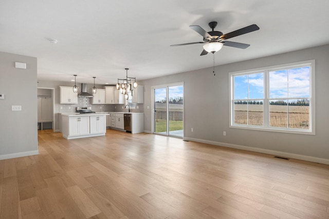 507 Wheatley Dr, Mahomet, IL 61853 - unfurnished living room with a sink, ceiling fan with notable chandelier, light wood-style floors, and visible vents