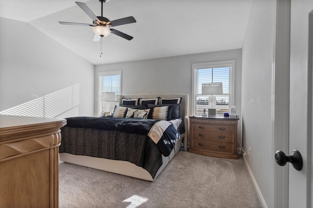 bedroom with ceiling fan, light colored carpet, multiple windows, and lofted ceiling