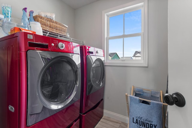 clothes washing area featuring light hardwood / wood-style floors and washer and clothes dryer