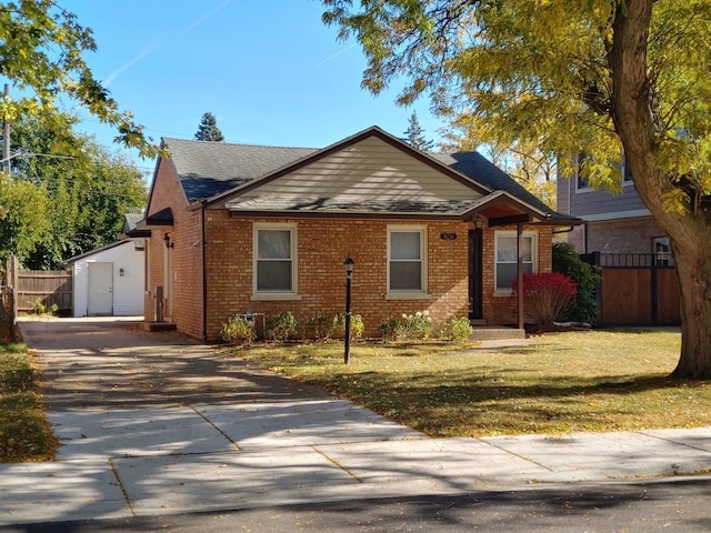 view of front of home featuring an outbuilding, a front yard, and a garage