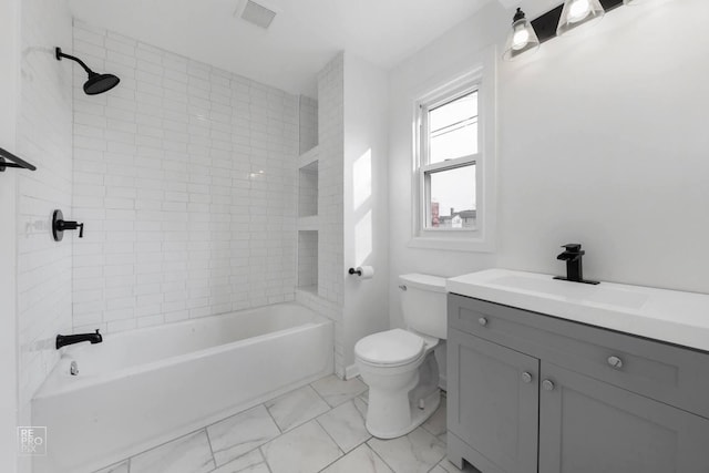 full bathroom featuring tiled shower / bath, vanity, and toilet