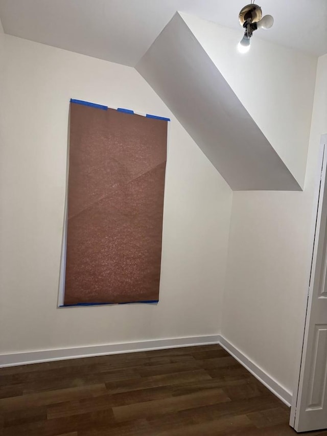 additional living space featuring dark hardwood / wood-style flooring and vaulted ceiling