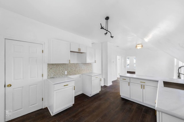 kitchen with decorative backsplash, white cabinetry, hanging light fixtures, and sink