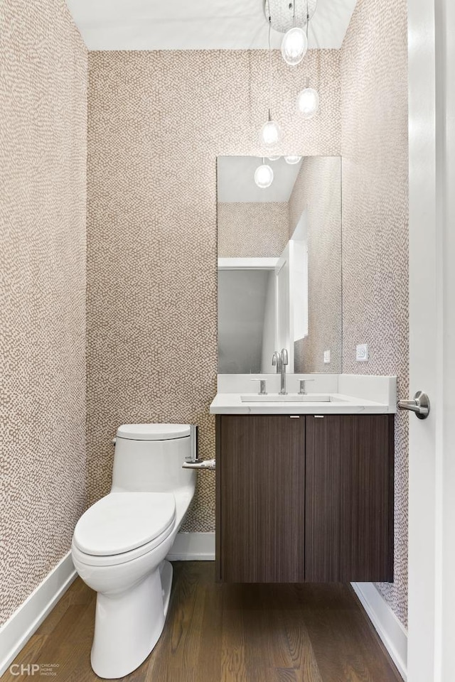 bathroom featuring vanity, wood-type flooring, and toilet