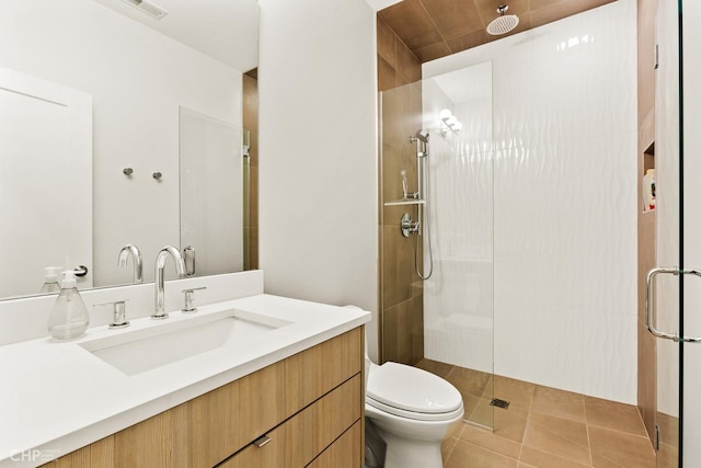 bathroom with tile patterned floors, vanity, toilet, and walk in shower