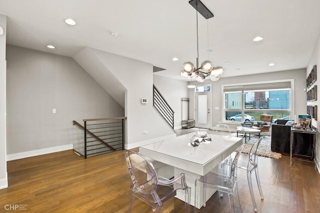 dining room with dark wood-type flooring and an inviting chandelier