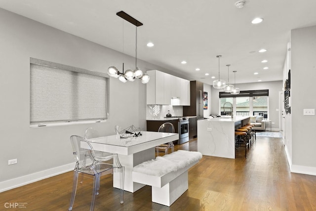 dining room with dark hardwood / wood-style flooring, a chandelier, and sink