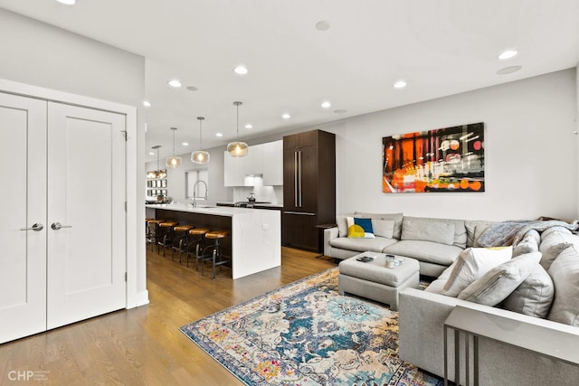 living room with sink and light hardwood / wood-style floors