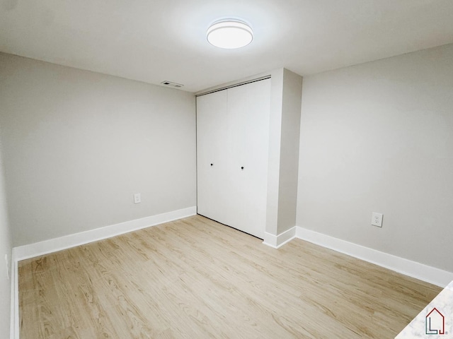 unfurnished bedroom featuring a closet and light hardwood / wood-style flooring