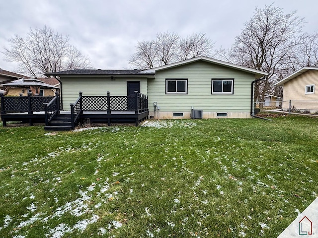 rear view of property with central AC unit, a wooden deck, and a lawn