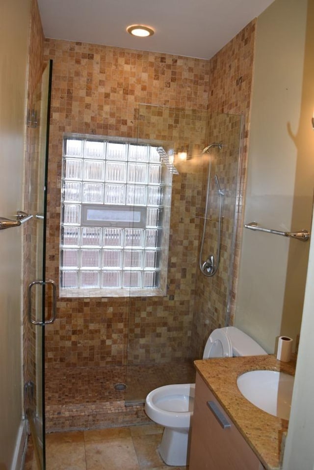 bathroom with toilet, vanity, and walk in shower