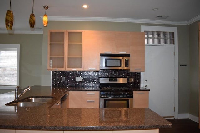 kitchen with decorative light fixtures, dark stone countertops, sink, and stainless steel appliances