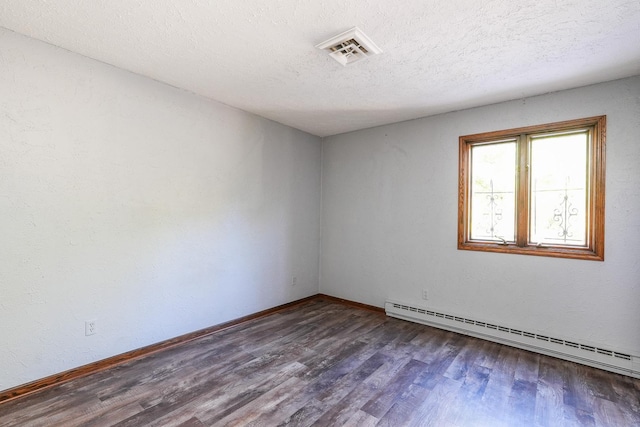 empty room featuring dark wood-type flooring, a baseboard radiator, and a textured ceiling