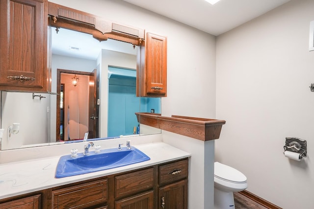 bathroom featuring hardwood / wood-style floors, vanity, and toilet