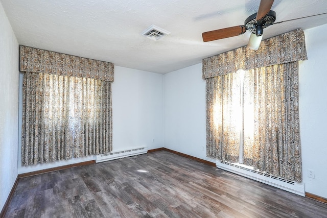 spare room with a textured ceiling, ceiling fan, dark hardwood / wood-style floors, and baseboard heating