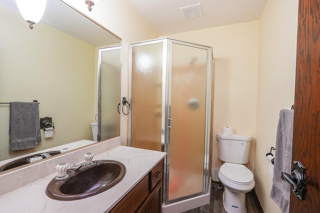 bathroom featuring hardwood / wood-style floors, vanity, toilet, and a shower with shower door