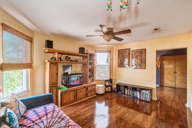 living room with ceiling fan, dark wood-type flooring, and a wealth of natural light