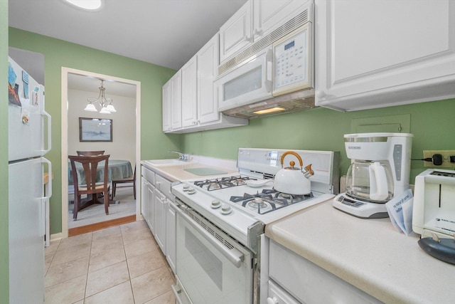 kitchen featuring white cabinets, white appliances, a chandelier, and light tile patterned flooring