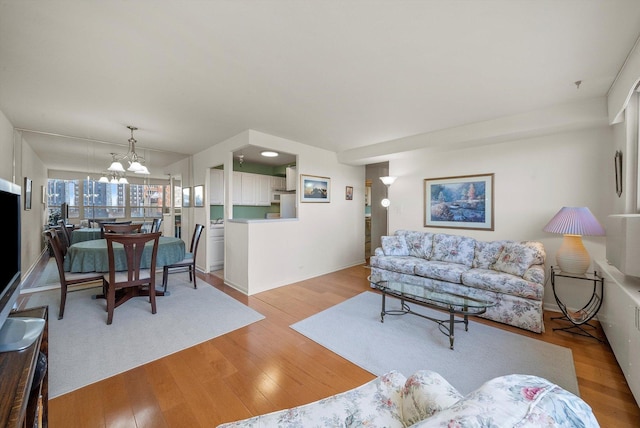 living room featuring light hardwood / wood-style floors and a notable chandelier