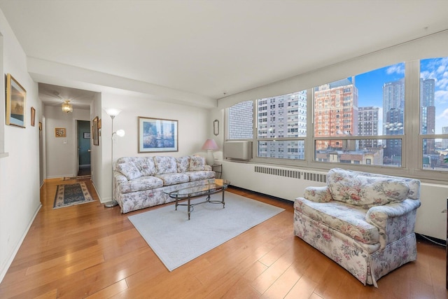 living room with radiator heating unit and light hardwood / wood-style flooring