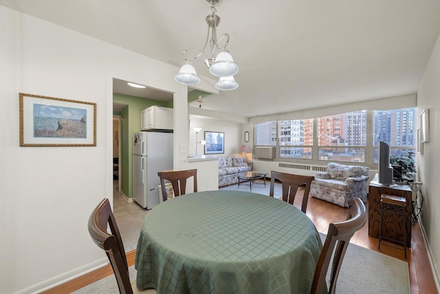 dining area with a notable chandelier and light hardwood / wood-style flooring