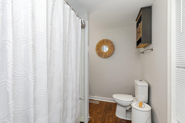 bathroom featuring hardwood / wood-style flooring and toilet