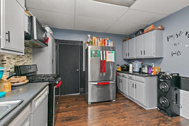 kitchen featuring a paneled ceiling, stainless steel appliances, sink, dark hardwood / wood-style floors, and white cabinetry