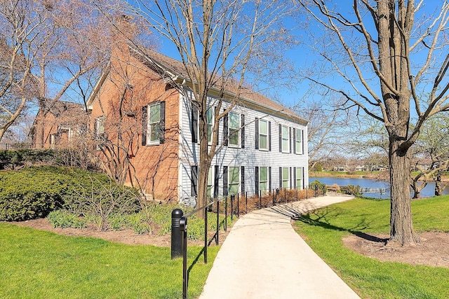 view of front facade with a front lawn and a water view