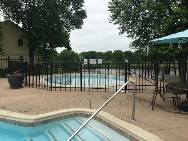 view of pool with an in ground hot tub and a patio area