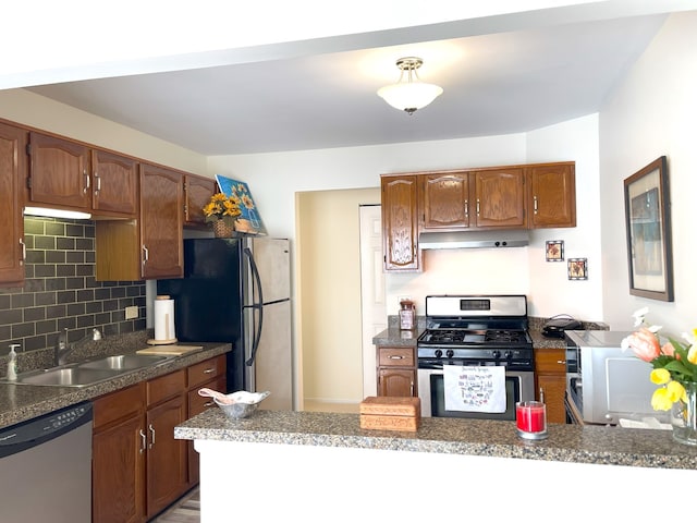 kitchen with sink, decorative backsplash, kitchen peninsula, and appliances with stainless steel finishes