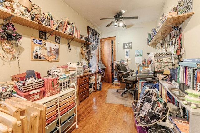 home office with light hardwood / wood-style floors and ceiling fan