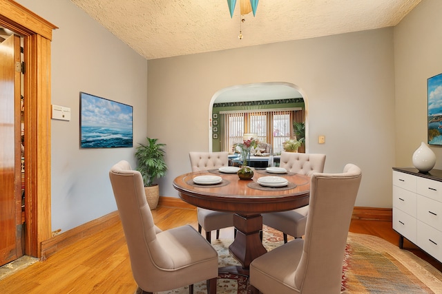 dining room featuring a textured ceiling and light hardwood / wood-style flooring