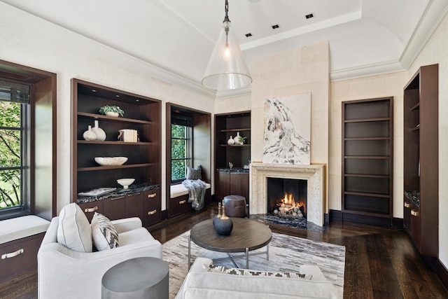 living room featuring a fireplace, built in shelves, dark hardwood / wood-style flooring, and a healthy amount of sunlight